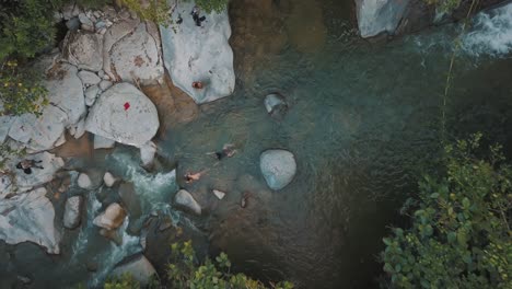 Drone-aerial,-top-view-of-a-natural-river-with-people-swimming-in-Colombia