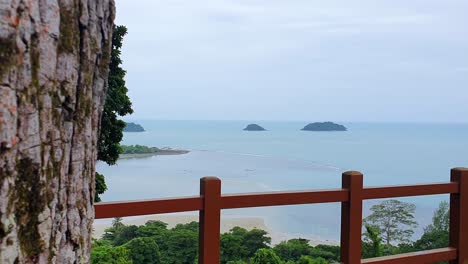 Panning-from-Behind-the-Tree-Trunk-to-the-scenic-view-of-the-Islands-in-the-Ocean-on-Koh-Chang-Island,-Thailand,-Asia