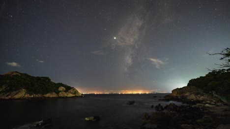 Night-time-illuminated-Cheung-Chau-coastline-under-energetic-milky-way-shooting-star-aircraft-night-sky-timelapse