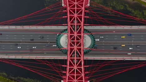 AERIAL-SLOWMOTION-static-scene-top-down-view-of-the-car-on-the-red-highway-bridge-over-the-river,-Moscow,-Russia