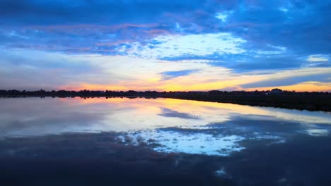 Aerial:-Drone-flying-low-above-the-perfectly-reflecting-water-at-stunning-sunrise