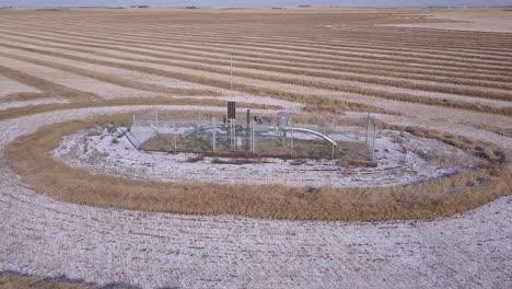 Rotating-aerial-of-pipeline-monitor-in-Alberta-wheat-field-with-snow