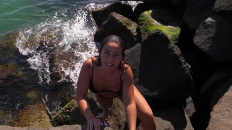 Mädchen-Im-Schwarzen-Bikini-Klettern-Auf-Den-Felsen---Meereswellen-Am-Strand-Von-Duranbah-Im-Sommer---New-South-Wales,-Australien