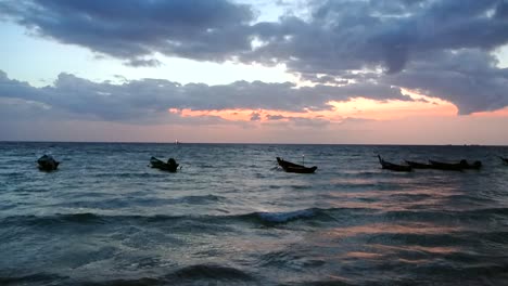 Ruhige-Fischerboote,-Die-Auf-Dem-Meer-Schwimmen,-Das-Von-Einem-Farbenfrohen-Sonnenuntergang-Gebadet-Wird