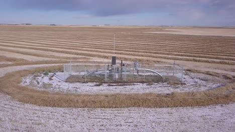 Rotating-aerial:-Natural-gas-pipeline-monitor-in-wheat-field,-horizon