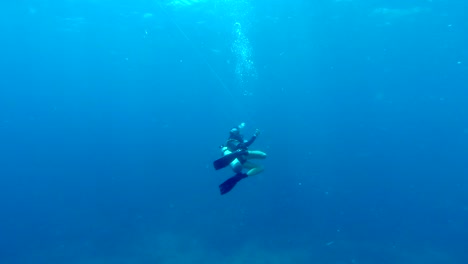 Buzo-Solitario-Nadando-A-Través-Del-Océano-Azul-Abierto-Desenrollando-Una-Cuerda-Guía