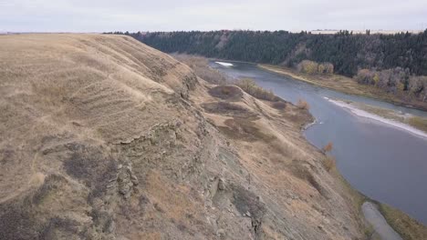 Aerial:-Low-eroded-cliffs-embank-dry-river-valley-hillside-in-autumn