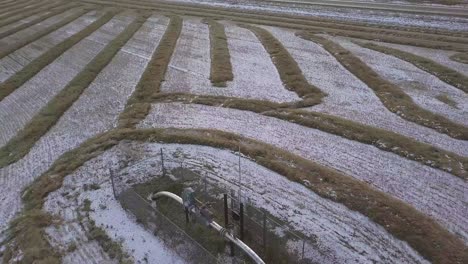 Aerial:-Dusting-of-snow-on-gas-pipeline-monitor-in-prairie-wheat-field