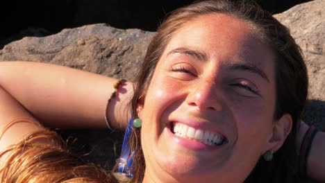 Cheerful-Woman-Lying-On-The-Coastal-Rock---Girl-Sunbathing-At-Duranbah-Beach---New-South-Wales,-Australia