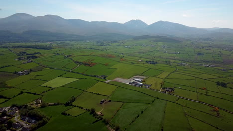 Drone-shot-of-rural-farmland-with-mountains-in-the-background