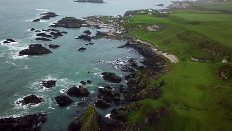 Filmische-Luftaufnahme-Der-Felsigen-Küste-In-Nordirland-Nach-Unten