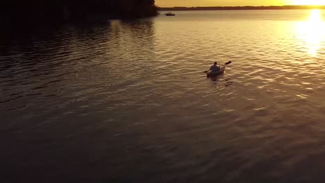 Orbital-drone-over-kayaker-at-sunrise-on-Lake-Michigan