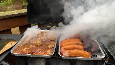 White-Smoke-Rising-Over-The-Aluminum-Foil-Tray-With-Marinated-Meat-And-Sausages---Grilling-Barbecue