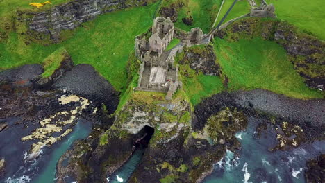Rotating-drone-shot-of-Dunluce-Castle,-now-ruined-medieval-castle-in-Northern-Ireland