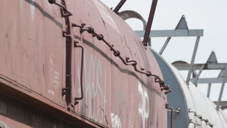 Low-angle-closeup-of-freight-train-cars-passing-by