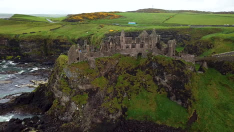 Amazing-drone-shot-of-Dunluce-Castle,-now-ruined-medieval-castle-in-Northern-Ireland