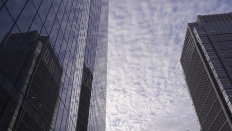 Ruhige-Und-Entspannende-Ansicht-Von-Wolkenkratzern,-Die-Einen-Schönen-Bewölkten-Himmel-In-Zeitlupe-Reflektieren