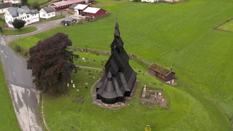 Schwarze-Christliche-Holzstabkirche-In-Der-Landschaft-Norwegens