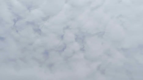Vista-Vertical-De-Mirar-Hacia-El-Cielo-Azul-Claro-Con-Nubes-De-Polvo-Gris-Y-Blanco
