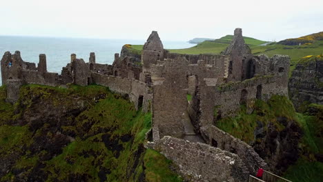 Cinematic-drone-shot-of-Dunluce-Castle,-now-ruined-medieval-castle-in-Northern-Ireland
