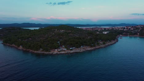 Aerial-view-rising-high-above-Adriatic-Sea-durin-sunset-revealing-Slanica-Beach-and-camping-area-in-Croatia-in-4k