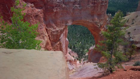 Slow-panning-shot-with-rack-focus-from-rock-in-the-foreground-to-a-sandstone-hoodoo-arch-in-the-background