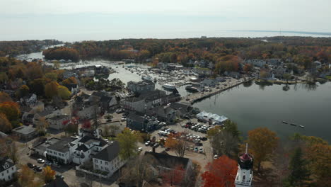 Aerial-view-of-town-center-along-a-river-in-fall,-Kennebunkport,-Maine