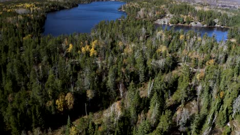 Aerial-dolly-forward-of-blue-lakes-nestled-in-a-boreal-forest-in-the-idyllic-Canadian-shield