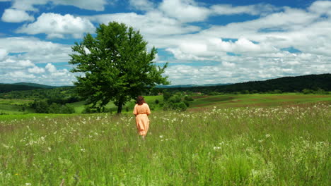Woman-walking-through-open-meadow-in-Lika,-Croatia