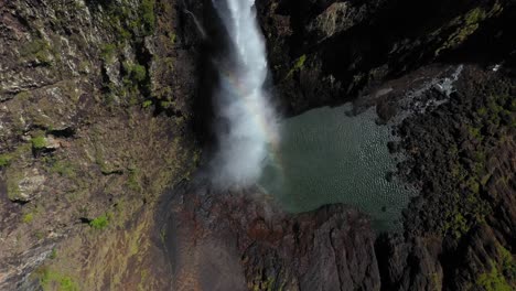 Spectacular-waterfall-spray-cascading-into-plunge-pool,-aerial-top-down-view