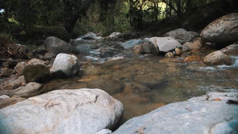 Schöne-Zeitlupenaufnahme-Von-Wasser,-Das-Durch-Felsen-In-Einem-Fluss-Mitten-Im-Dschungel-Fließt