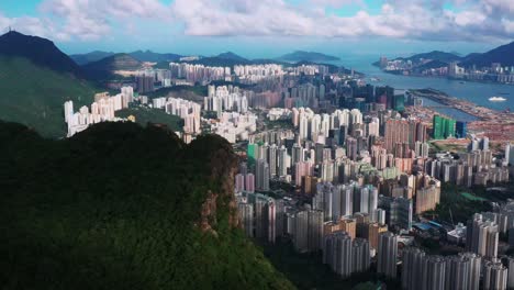 Kowloon-Lion-rock-mountain-peak-overlooking-downtown-skyscraper-business-district-Hong-Kong-aerial-orbit-left