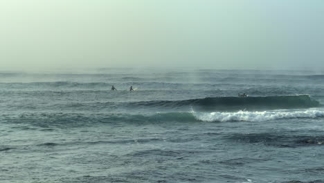 Surfers-surfing-on-a-foggy-morning