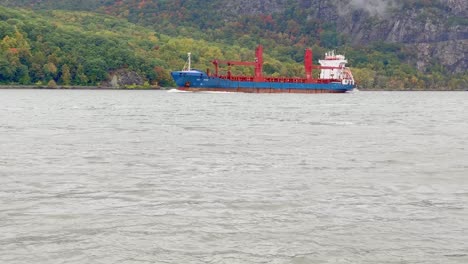 A-cargo-ship-on-the-hudson-river-during-fall-in-new-york's-hudson-valley-on-a-rainy-day-with-low-clouds