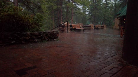 Handheld-shot-of-hard-rain-coming-down-outside-a-forest-lodge-in-60-FPS