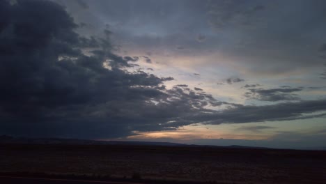 Wide-static-shot-of-storm-clouds-during-a-desert-sunset