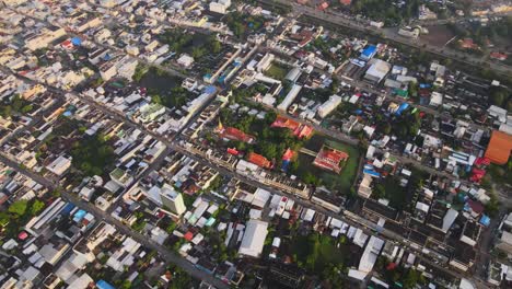 AERIAL:-Drone-shot-of-a-Buddhist-Temple-Surrounded-by-Densely-Populated-City-of-Korat,-Thailand