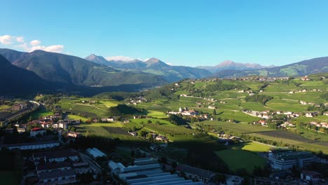 Aerial-view-of-Austrian-Alps-with-village-and-green-grass-fields-fying-rising-high-during-sunny-summer-day-between-Austria-and-Germany-in-4k