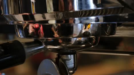 Close-up-of-locking-in-a-portafilter-on-an-espresso-machine-in-a-coffee-shop