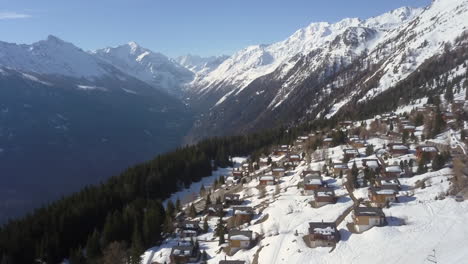Vista-Aérea-Del-Pueblo-De-Esquí-Y-La-Impresionante-Cordillera-En-Los-Alpes-Suizos