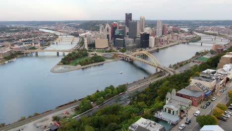 Cinematic-aerial-establishing-shot-of-downtown-Pittsburgh-PA,-USA,-shot-above-Mount-Washington-during-autumn-magic-hour,-three-rivers