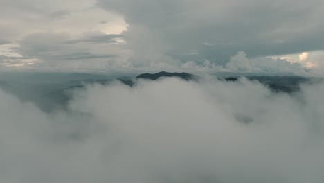 Drone-aerial-shot-flying-through-clouds-moving-fast-in-a-misty-day