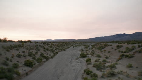 Vuelo-A-Baja-Altura-Sobre-Un-Cauce-Seco-Hacia-Las-Montañas-En-El-Desierto-De-Mojave