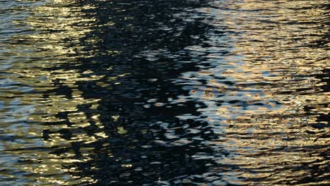 Reflexionen-In-Der-Meerwasseroberfläche,-Funkelnde-Schwarze-Und-Goldene-Wasserschleife,-Hintergrund-Der-Wasseroberfläche,-Mehrfarbige-Wasseroberfläche,-Schöner-Schleifenhintergrund-4k