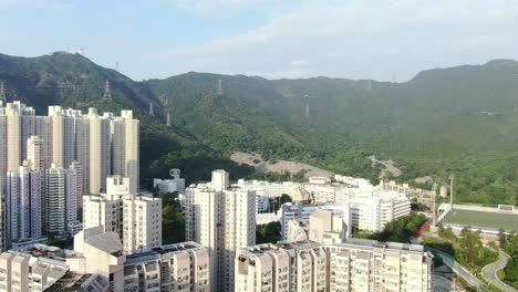 Mega-Edificios-Residenciales-En-El-Centro-De-Hong-Kong-Y-Lion-Rock-Mountain-Ridge-En-El-Fondo,-Vista-Aérea