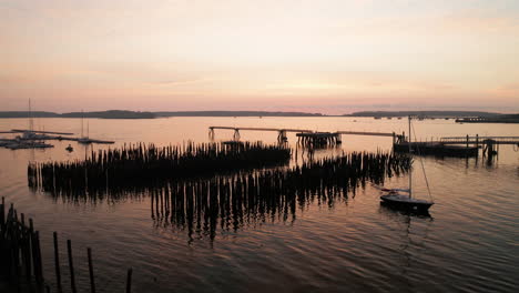 Beautiful-sunrise-of-Portland-Maine-port,-areal-shot-over-dock-pilings