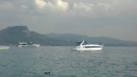 Slow-motion-shot-of-yachts-docked-in-a-scenic-landscape-at-Garda-Lake,-Italy