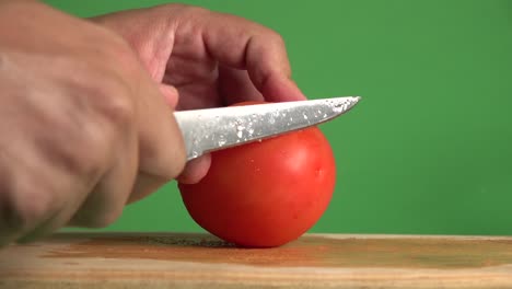 Ein-Messer,-Das-Horizontal-Durch-Eine-Tomate-Auf-Einem-Chroma-Hintergrund-Schneidet