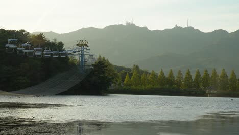 Der-Wundervolle-Fluss,-Der-Sich-Friedlich-Im-Seoul-Grand-Park-Unter-Dem-Hellen-Bewölkten-Himmel-Im-Herbst-Bewegt,-Umgeben-Von-Grünen-Bäumen-Und-Hohen-Bergen---Weitwinkelaufnahme