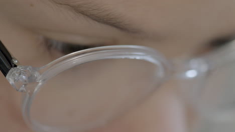 Extreme-closeup-on-face-of-a-young-boy-with-glasses-as-he-is-reading